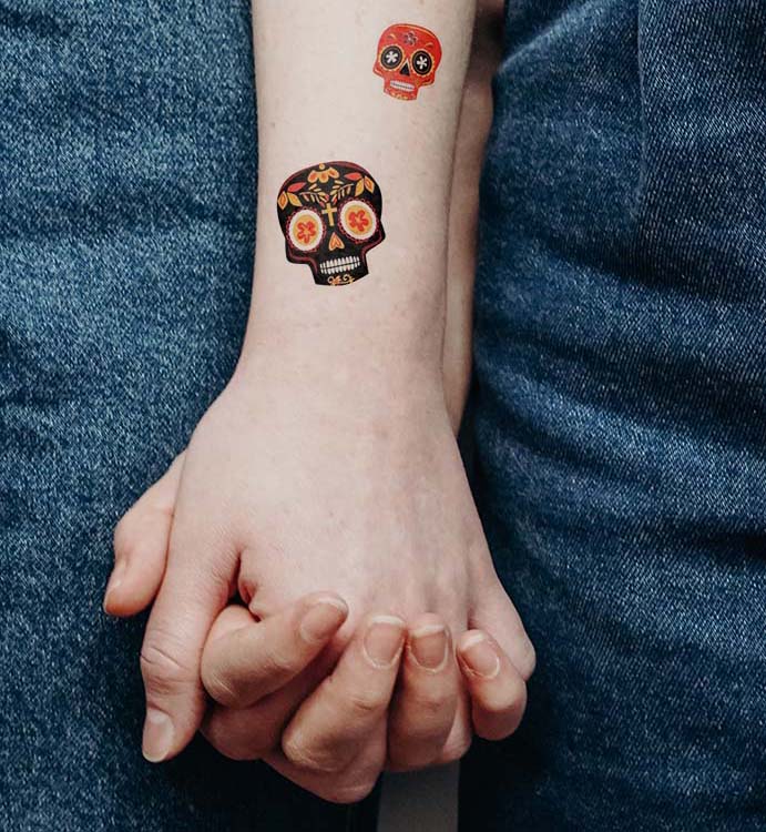 Skull tattoo on wrist and arm.