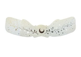 Freckle Tattoos Silver Moon är en dekorativ, halvmåneformad barrette med blom- och bladmönster med stjärnutskärningar, tillverkad av pärlemorskimrande material, inspirerad av Silver Moon-design.