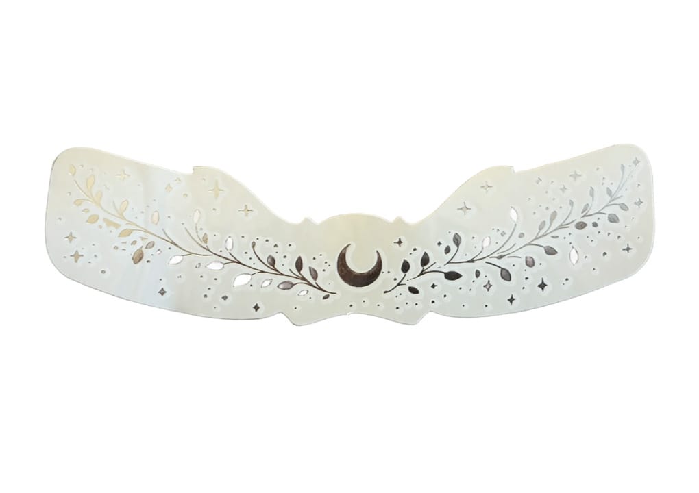 Fregnetatoveringer Silver Moon er et dekorativt, perlehvitt hårspenne med utskårne blad- og stjernemotiver på overflaten.