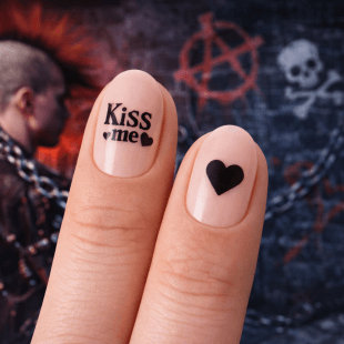 To fingre med svart neglelakk: på den ene står det Kiss me med små hjerter, på den andre er det et enkelt hjerte. I bakgrunnen en punkscene med graffiti, blant annet en hodeskalle, et anarkisymbol og en person med mohawk.